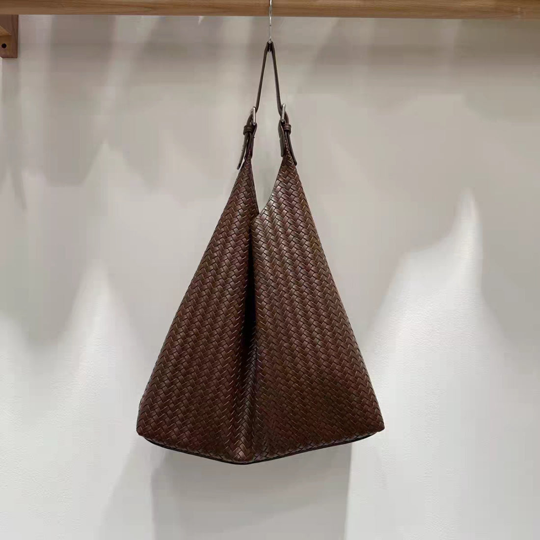 Cosbai woven slouchy hobo bag with single handle shown against plain background