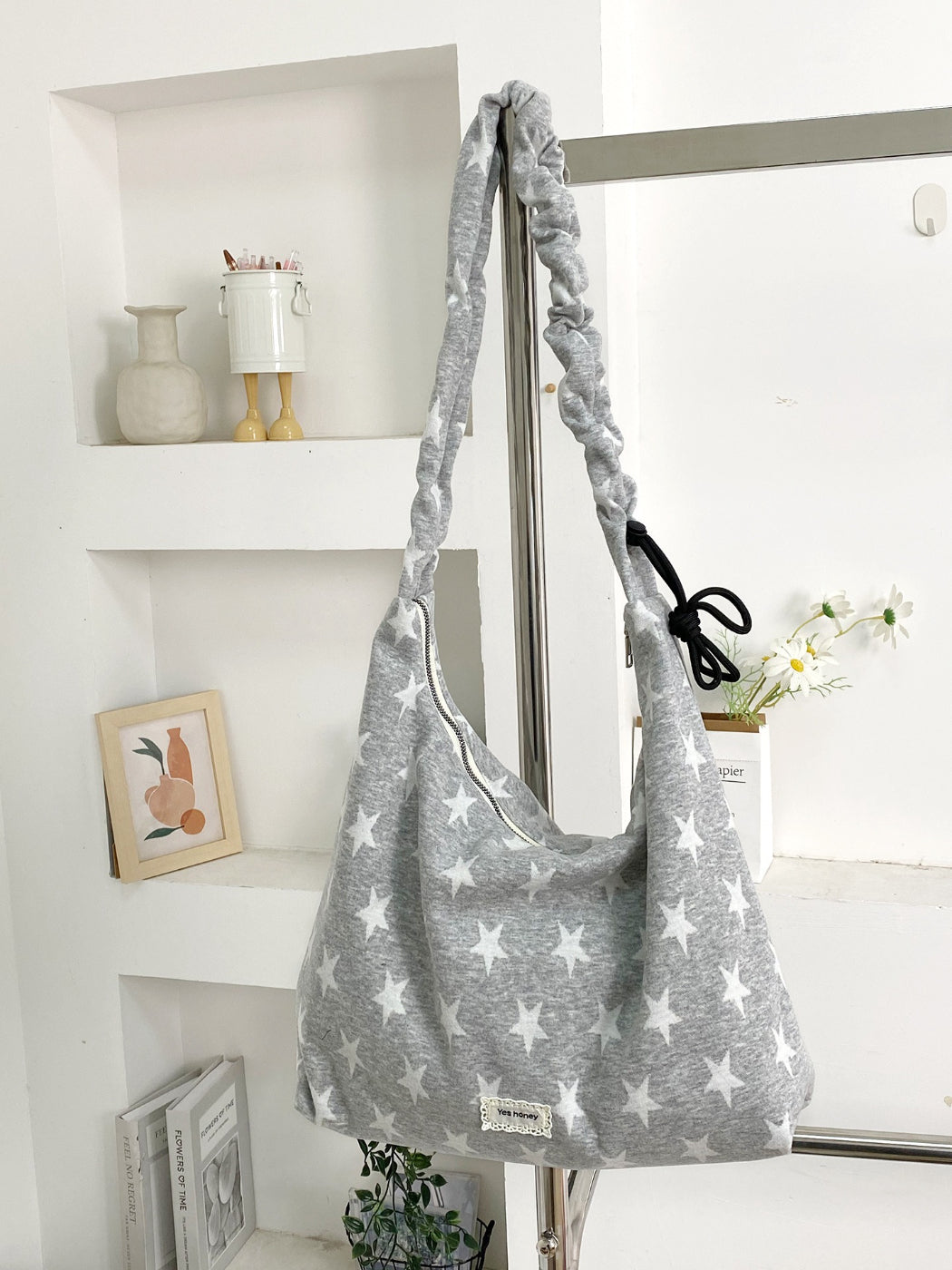 Cosbai star print slouchy shoulder bag placed on wooden surface
