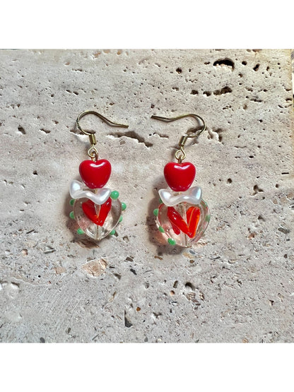Earwish Playful Apple Heart Earrings worn on a model's ear showcasing size and fit