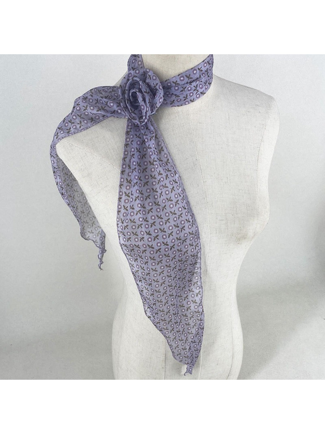 Side view of model wearing scarf tied in a bow at the neck
