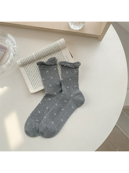 Rufia socks folded neatly with visible embroidered tiny flower pattern