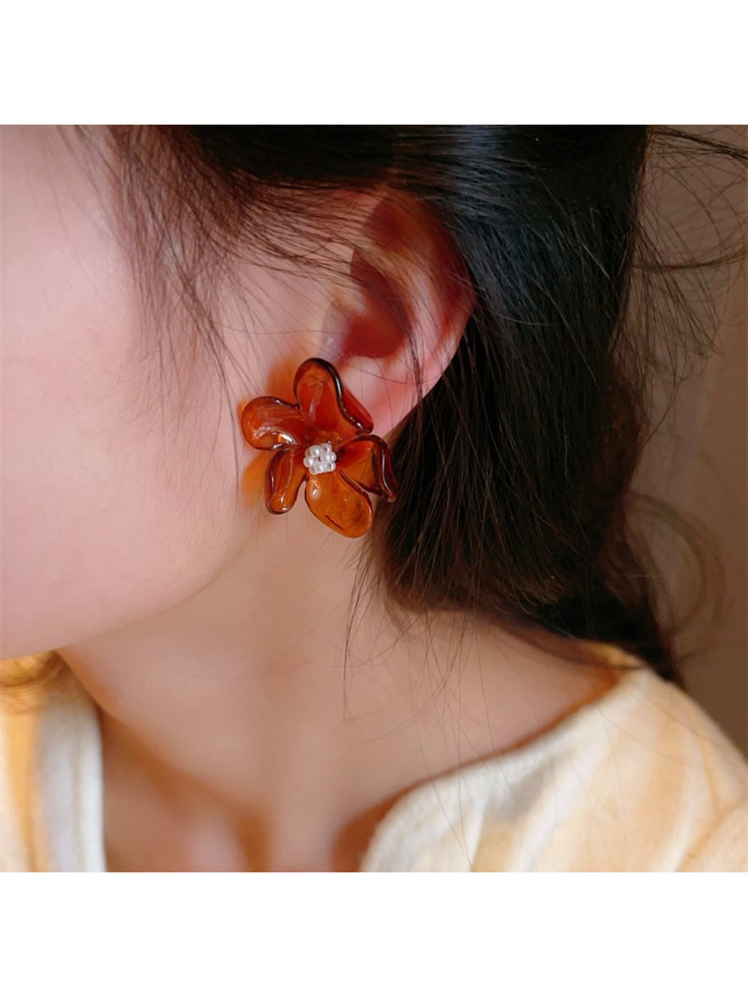 Close-up of glossy flower stud earring showing petal texture and shine