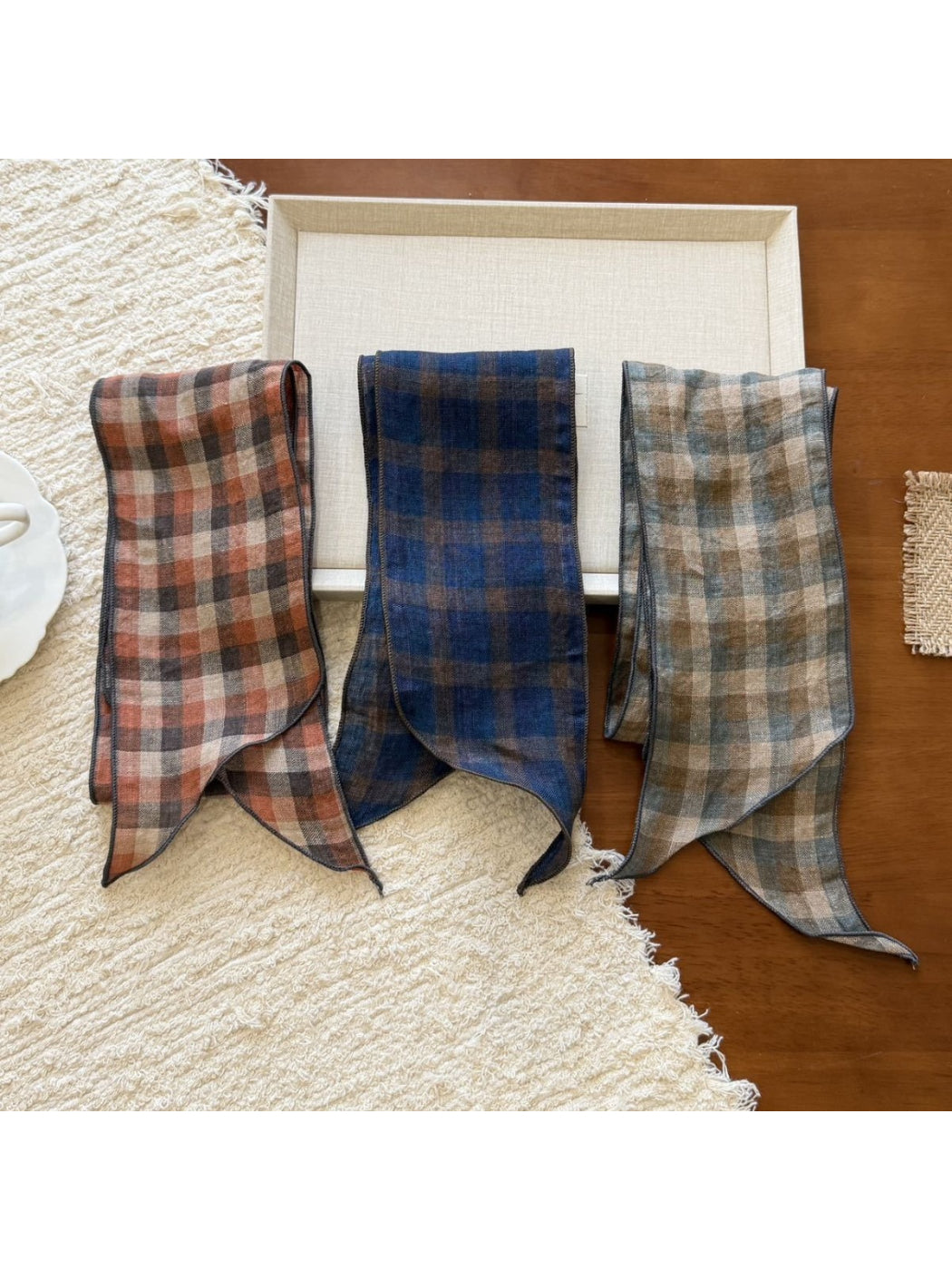 Classic plaid slim skinny scarf in beige, black, and red tones laid flat