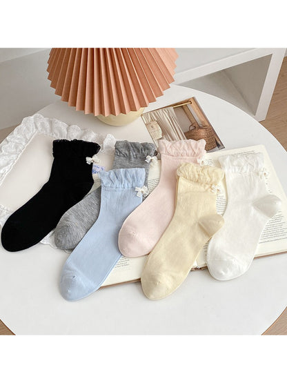 Pair of Rufia ruched ankle socks with bow charm displayed flat