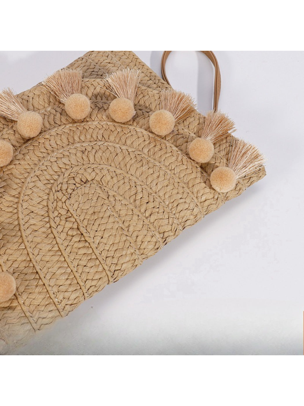 Side view of Cosbai woven tassel clutch bag showing thickness and tassels