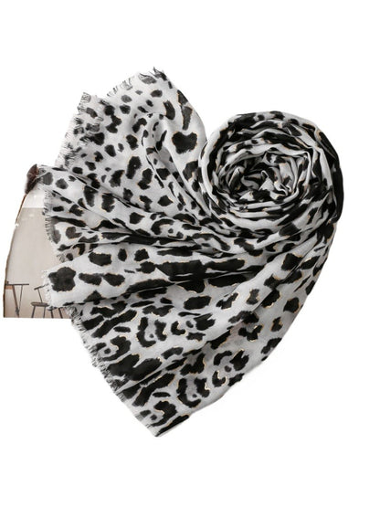 Close-up of snow leopard pattern on soft fabric scarf