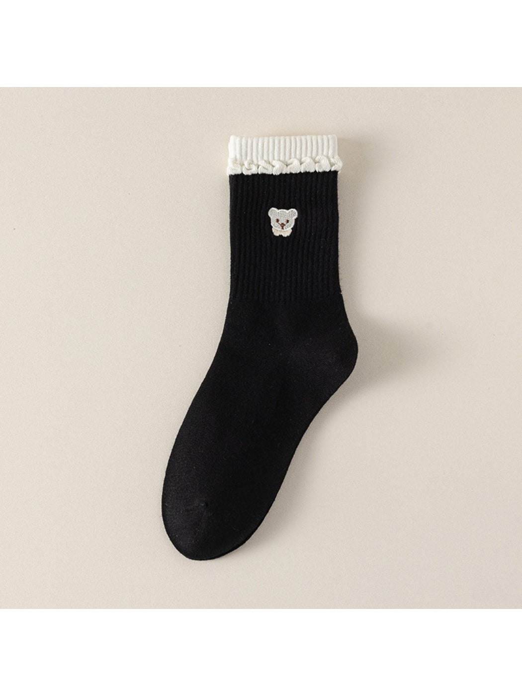 Pair of Rufia beige ribbed socks with teddy detail standing upright