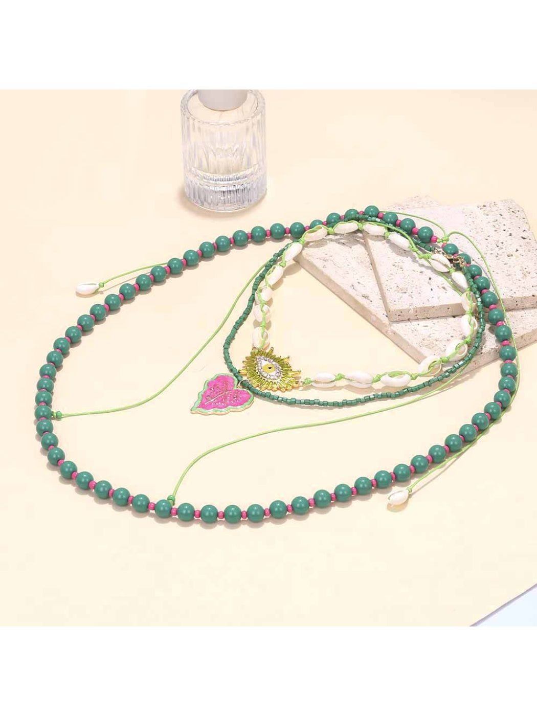 Neckit layered beaded necklace with leaf pendant displayed on a black surface