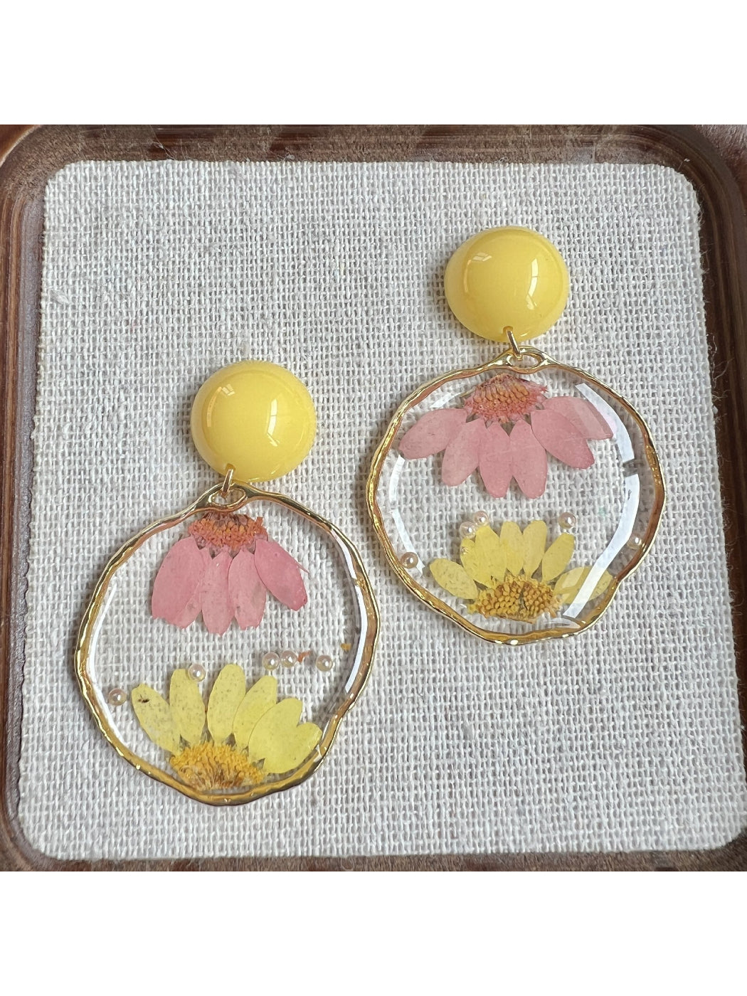 Clear floral earrings displayed on a white background with gold hardware