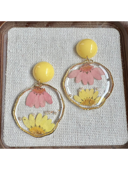 Clear floral earrings displayed on a white background with gold hardware