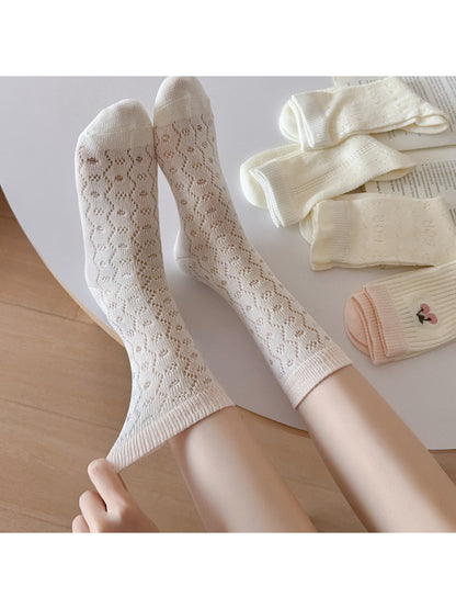 Pair of Rufia cherry open knit socks worn on feet showing delicate knit design
