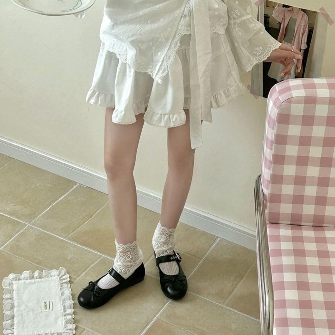 Pair of Rufia crew socks with delicate lace trim displayed flat on wooden surface