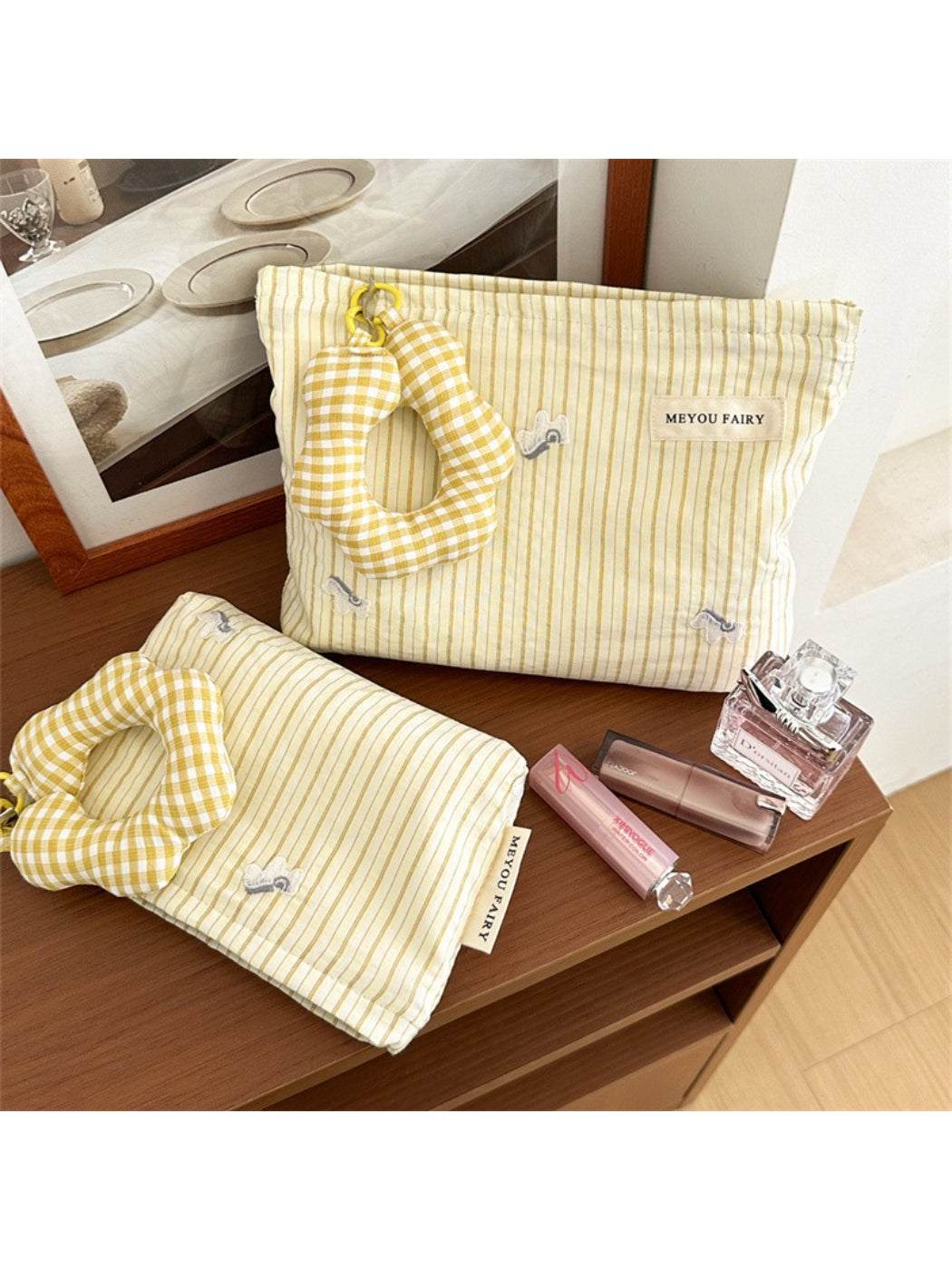 Striped cosmetic bag with attached plush charm on white background