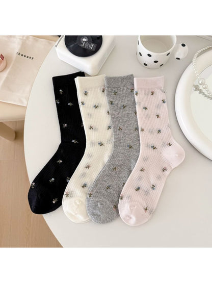 Close-up of Rufia crew socks showing detailed soft blossom floral pattern
