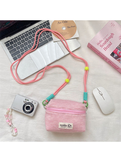 Side view of the Cosbai striped mini crossbody pouch highlighting its slim profile