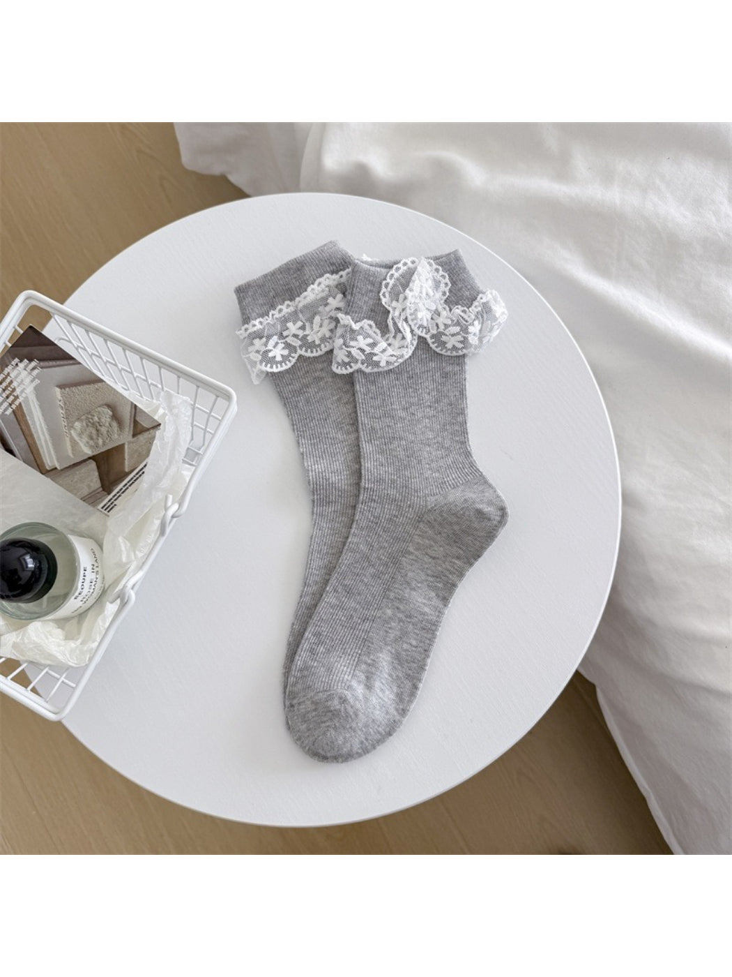 Pair of Rufia bow lace trim crew socks on wooden surface