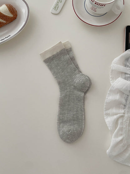 Stack of Rufia soft tone contrast ribbed socks in various neutral colors