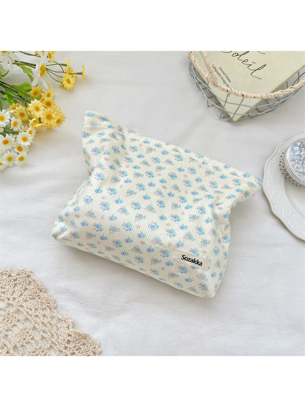 Cosbai cosmetic pouch placed on white surface with floral ribbed design visible