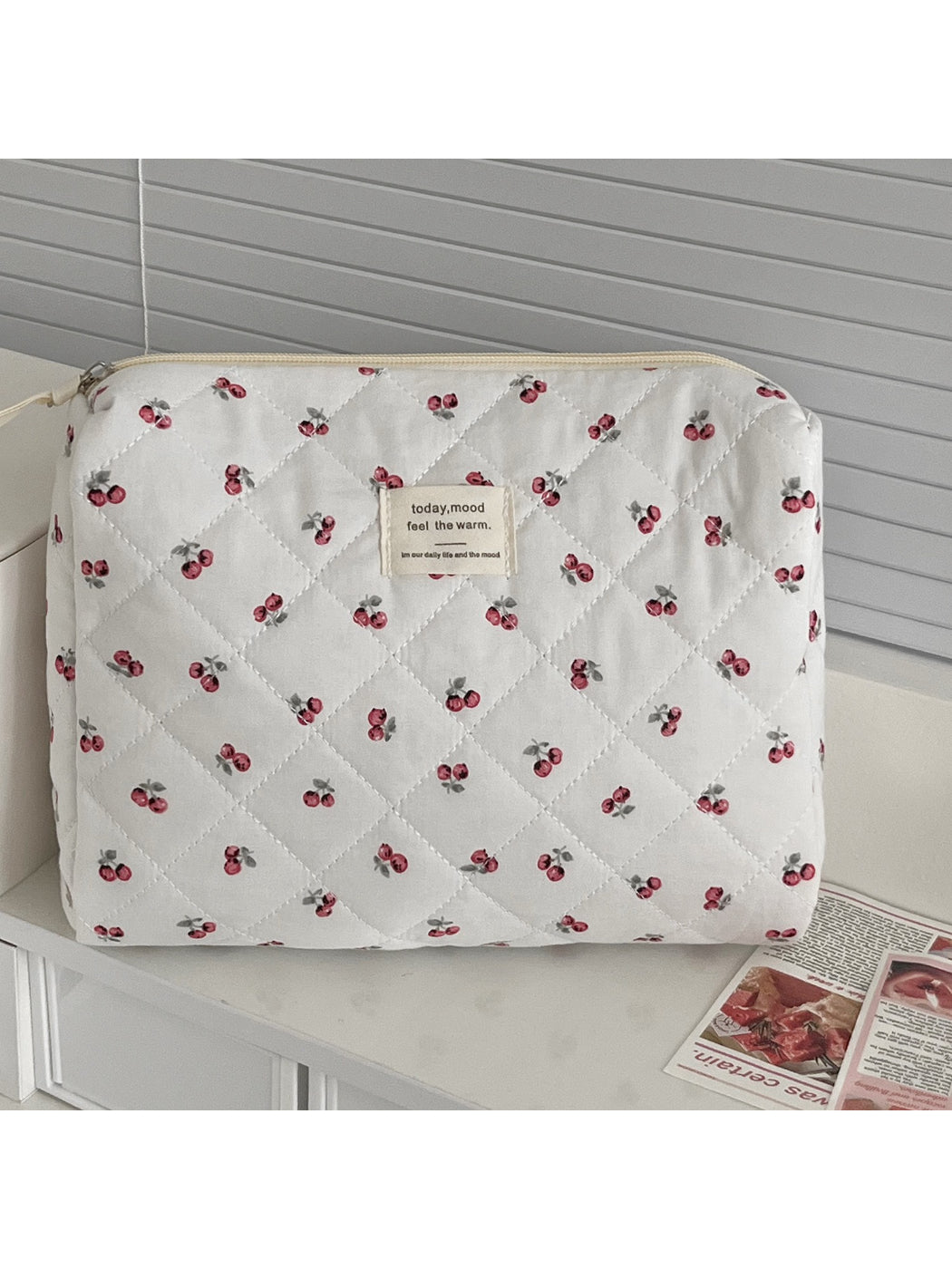 Close-up of quilted cherry design on soft fabric storage pouch