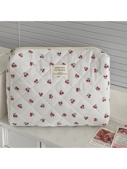 Close-up of quilted cherry design on soft fabric storage pouch