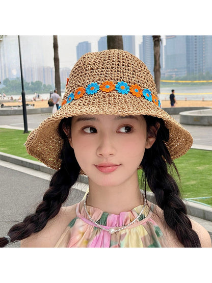 Model wearing Haila Daisy Chain woven sun hat outdoors with blue sky background