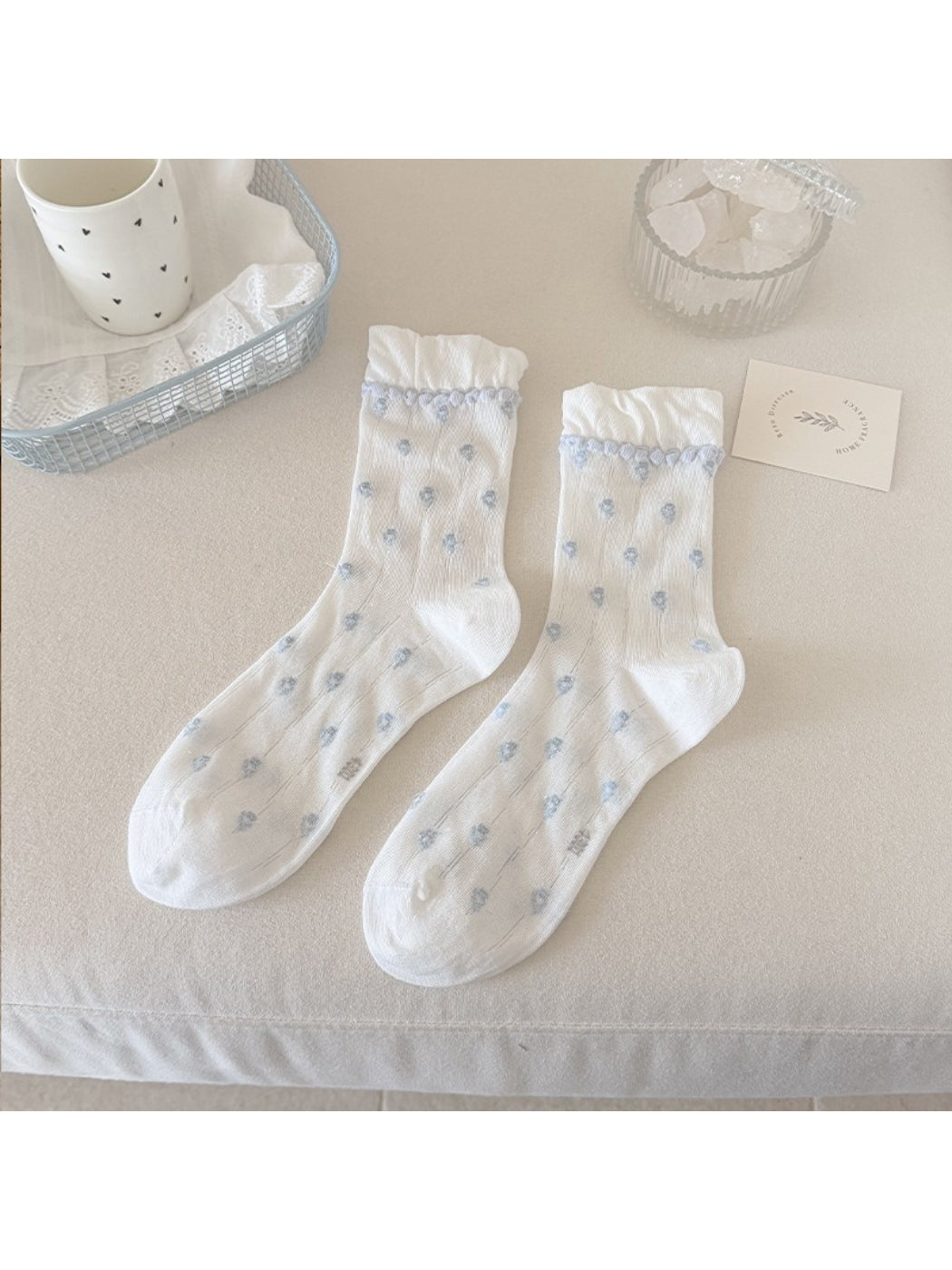 Rufia socks displayed flat highlighting floral design and pom pom edging
