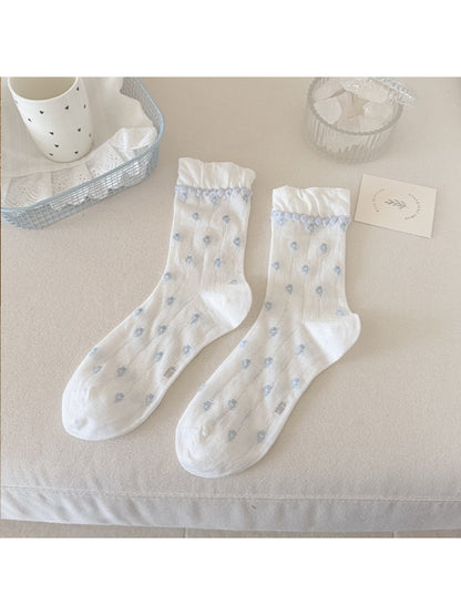 Rufia socks displayed flat highlighting floral design and pom pom edging