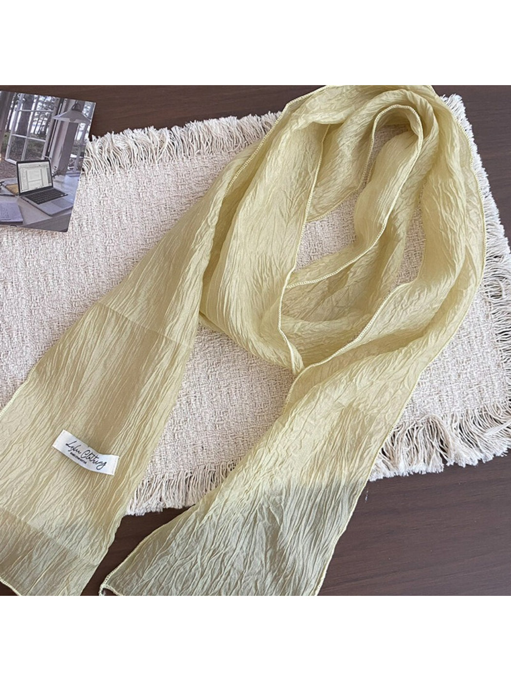 Folded lightweight pleated neck scarf displayed flat on a white surface