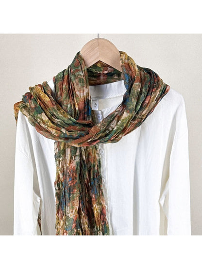 Scarvii scarf with textured painterly print in soft pastel colors, folded on a white background