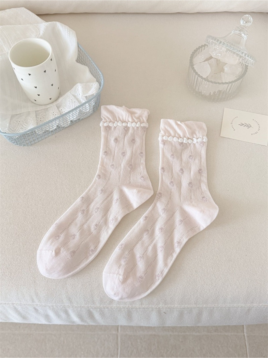Pair of Rufia dainty flower frill crew socks laid flat showing full design