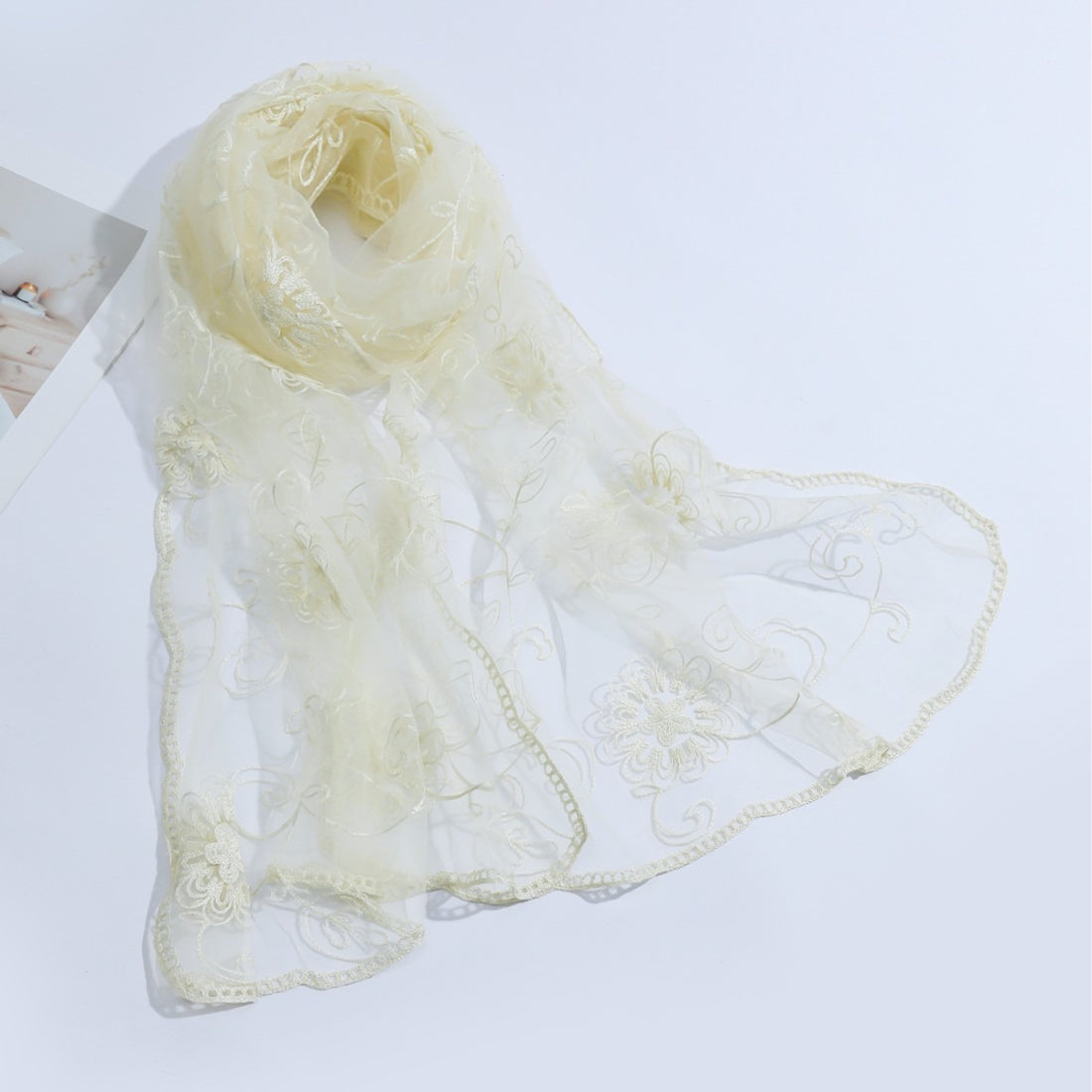 Lightweight sheer scarf with floral mesh pattern displayed flat