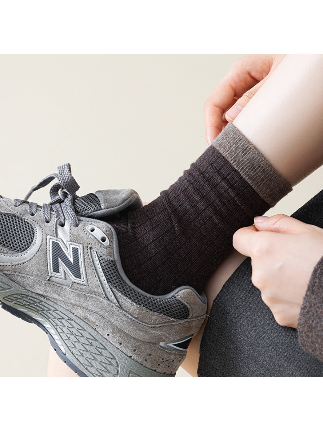 Model wearing Rufia ribbed mid-calf socks in beige with casual shoes