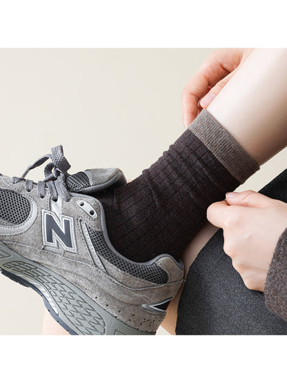 Model wearing Rufia ribbed mid-calf socks in beige with casual shoes