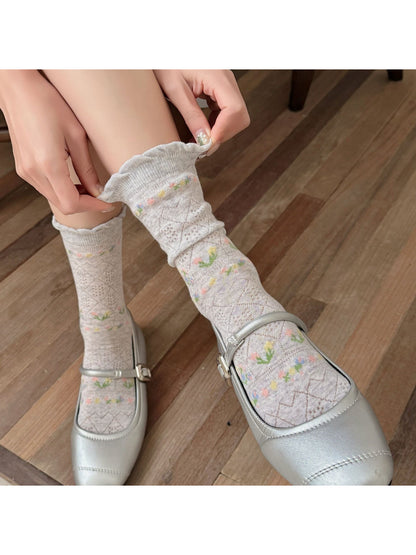 Rufia floral lace ankle socks folded neatly on a wooden surface