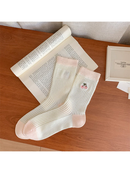Side view of Rufia dainty cherry socks highlighting open knit texture and cherry motifs