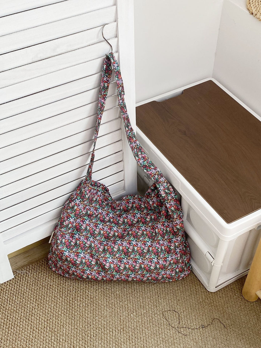 Cosbai soft floral shoulder bag resting on wooden surface with flowers