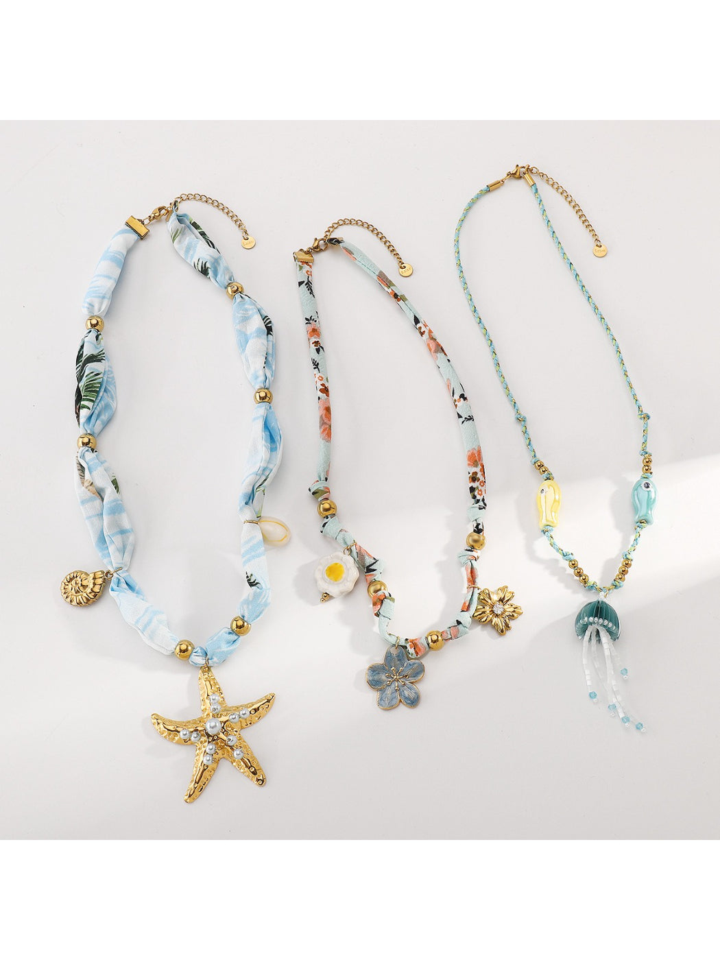 Ocean Charm beaded necklace laid out with ocean-themed props