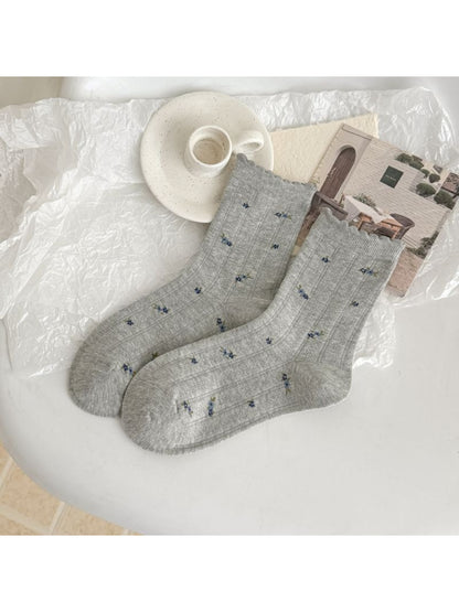 Pair of Rufia crew socks showing intricate lace and patterned fabric