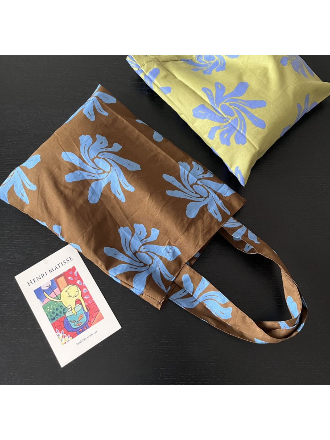 Model carrying Cosbai abstract floral reusable tote bag over shoulder