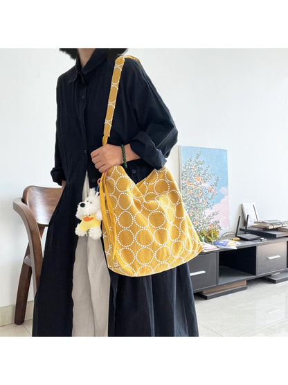 Close-up of Cosbai tote bag's textured circle pattern and dog charm on strap