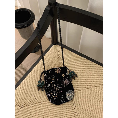 Side view of Cosbai beaded floral drawstring crossbody bag showing strap and floral beadwork