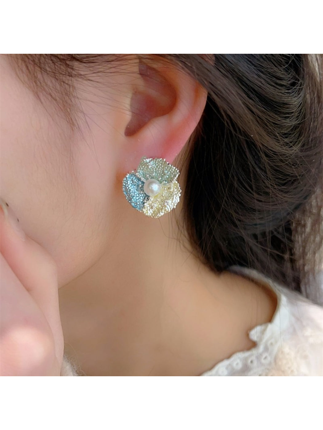 Earwish flower stud earrings displayed on a beige fabric surface