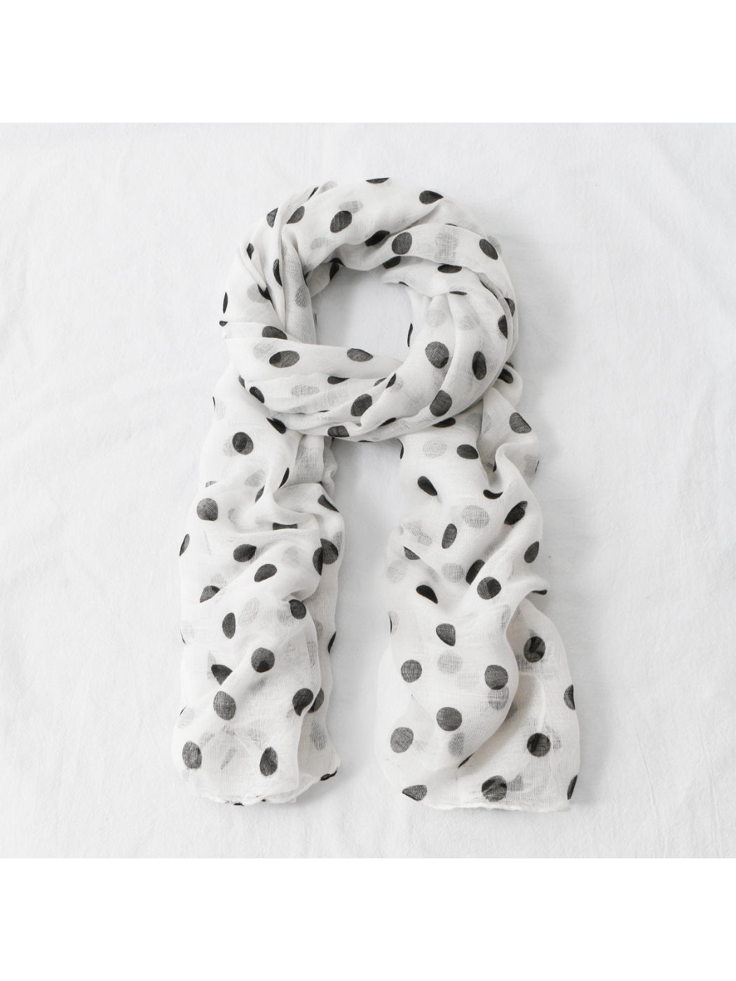 Side view of model wearing lightweight polka dot scarf over casual outfit