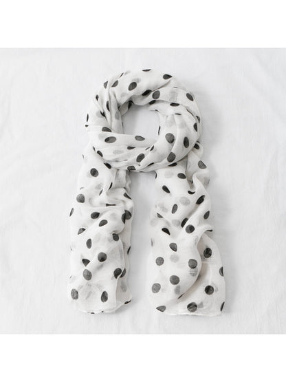Side view of model wearing lightweight polka dot scarf over casual outfit