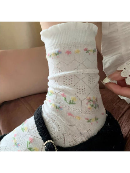 Rufia floral pointelle crew socks displayed flat showing detailed knit floral design