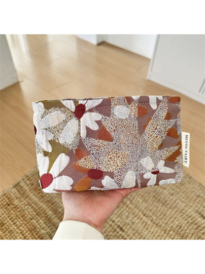 Cosbai floral makeup bag on a wooden surface with soft lighting