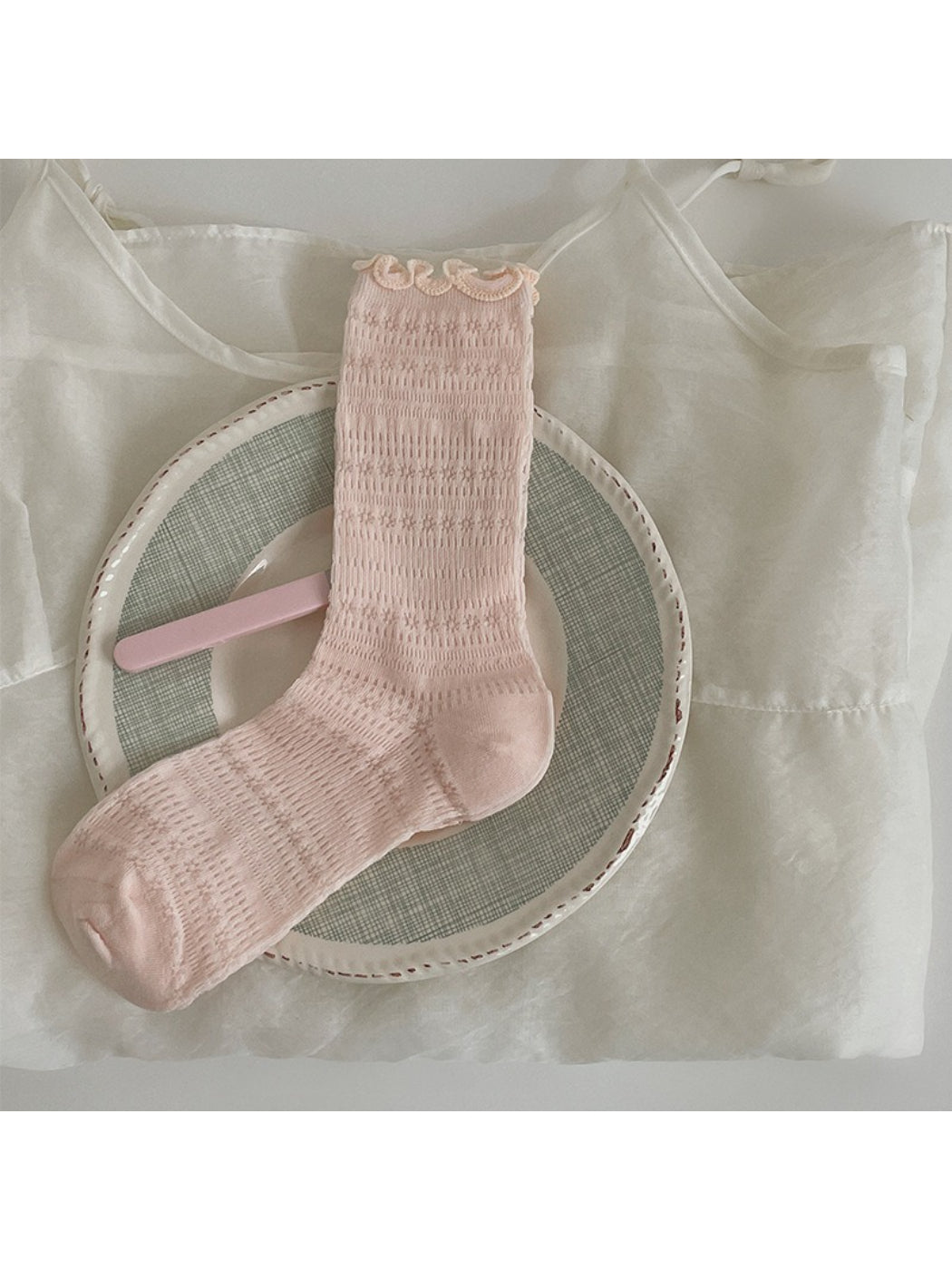 Multiple pairs of Rufia Sweet Ruffle Edge Socks in various pastel colors stacked