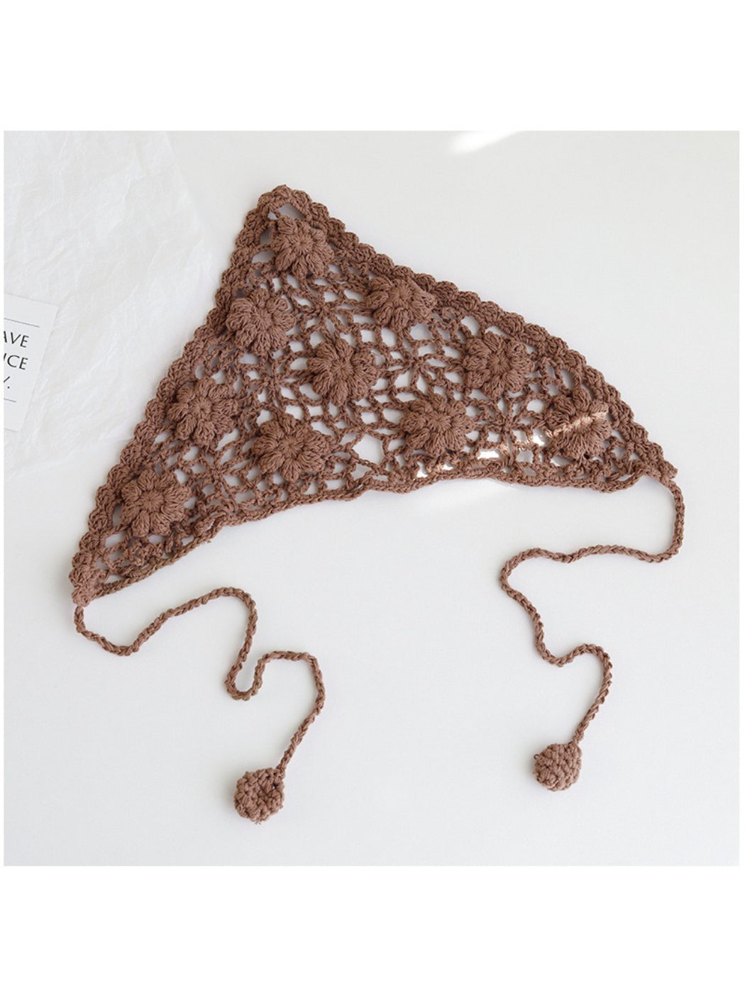 Top view of cream crochet headband highlighting intricate flower stitches