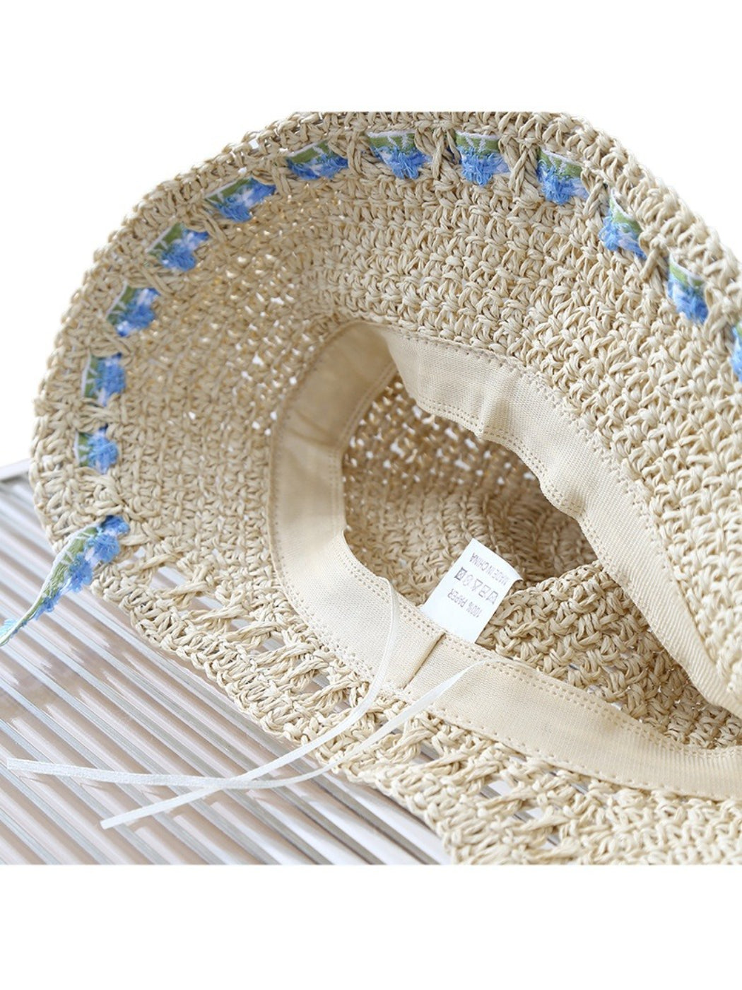 Top view of Haila floral trim straw bucket hat showing round crown and floral trim