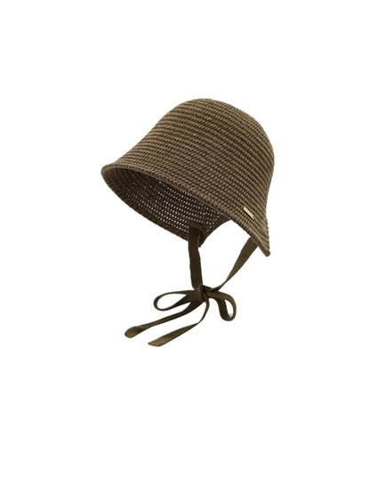 Haila woven straw bucket hat with ribbon tie displayed alongside summer accessories